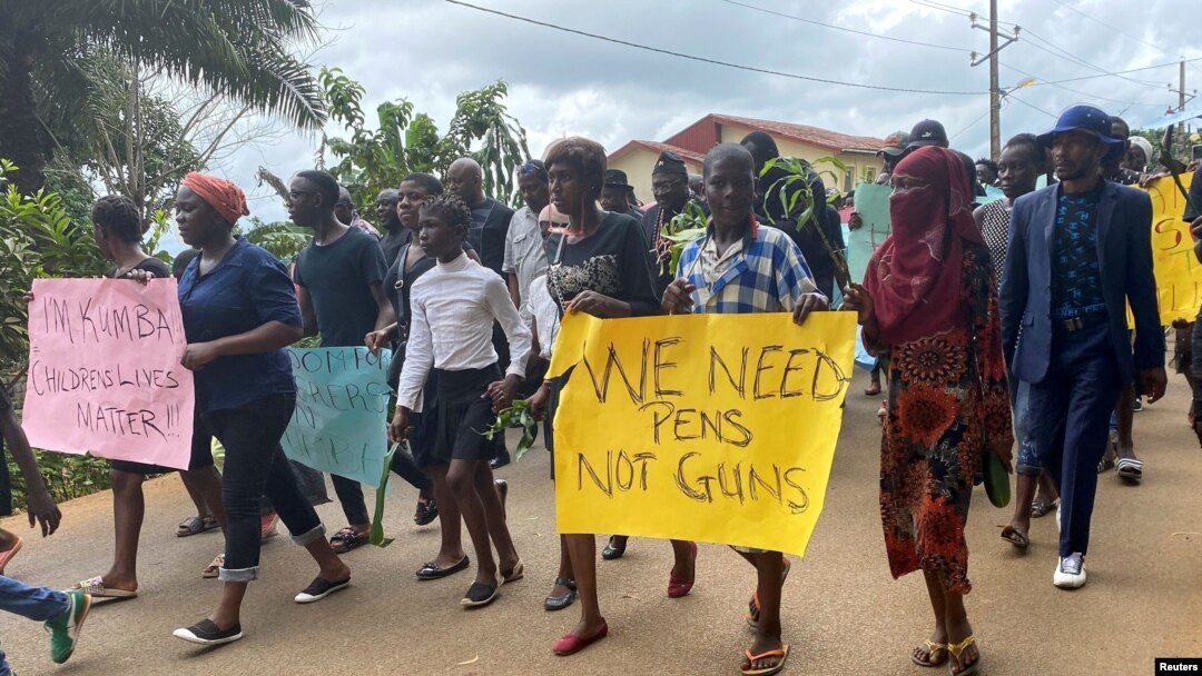 Schoolchildren, their parents and teachers hold a protest after gunmen opened fire at a school, killing at least six children as authorities claim, in Kumba, Cameroon, Oct. 25, 2020.