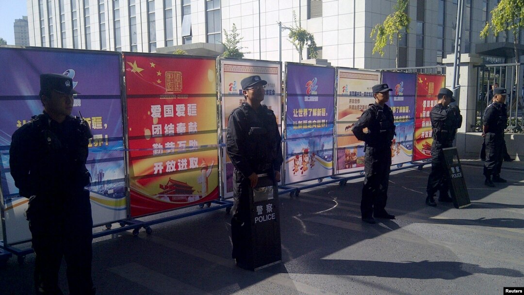 Policemen in riot gear guard a checkpoint on a road near a courthouse where ethnic Uighur academic Ilham Tohti's trial is taking place in Urumqi, Xinjiang Uighur Autonomous Region, Sept. 17, 2014.