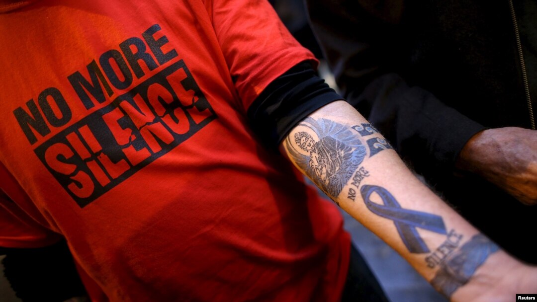 FILE - Paul Levely, a child sex abuse victim, wears a T-shirt that says "no more silence" and shows a tattoo on his arm in Rome, Italy, Feb. 28, 2016. The Catholic Church in Australia is rejecting laws forcing priests to report confessions of child abuse.
