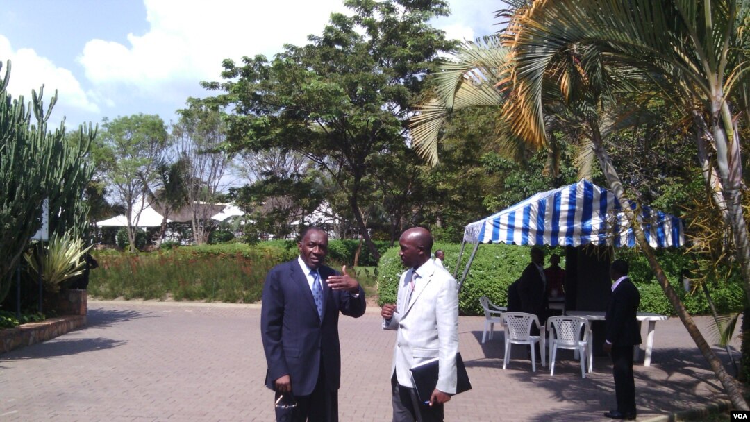 DRC Foreign Minister Raymond Tshibanda (L) and M23 Spokesman Rene Abandi discuss the situation, at DRC peace talks in Kampala, Uganda, Sept. 17. (VOA/A. Hall)