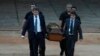 Agentes de la policía federal de Brasil cargan restos humanos recuperados que se cree son del experto indígena brasileño Bruno Pereira y el reportero británico Dom Phillips, el jueves 16 de junio de 2022, en el hangar de la Policía Federal, en Brasilia, Brasil.