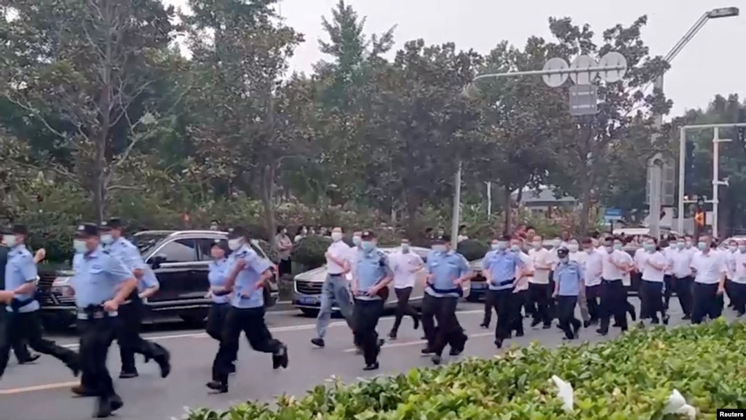 中國警察跑向河南鄭州中國人民銀行支行前抗議銀行凍結存款的儲戶們。(2022年7月10日)