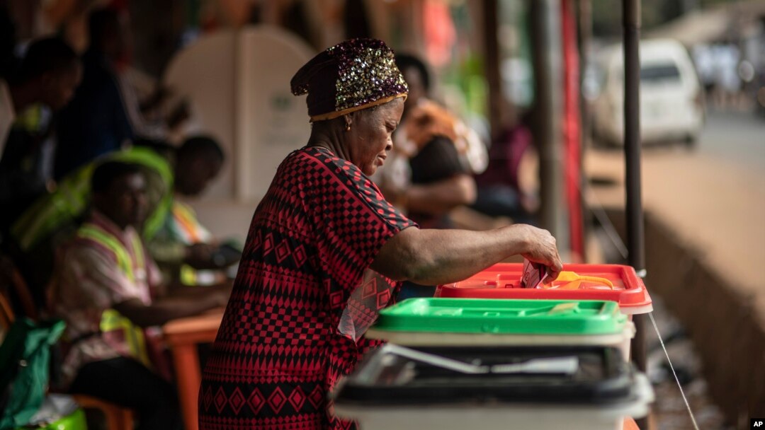 Mpiga kura atumbukiza vyeti vya kura yake kwenye sanduku mjini Agulu, Nigeria