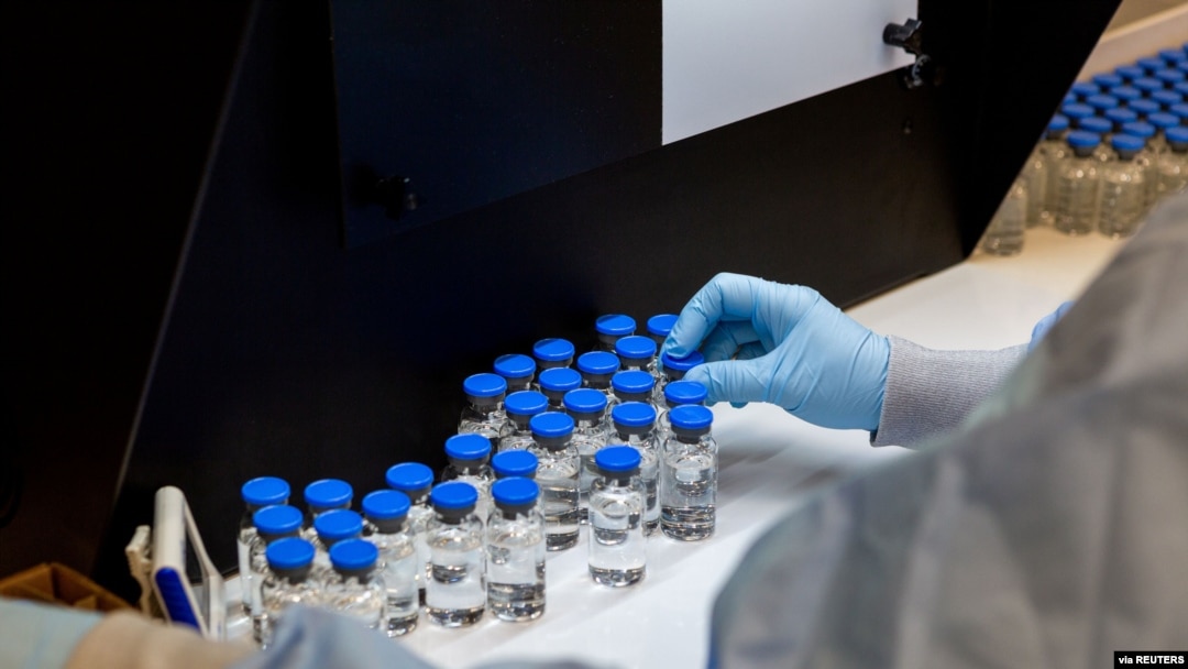 FILE - A lab technician inspects filled vials of the investigational coronavirus disease treatment drug remdesivir, at a Gilead Sciences facility in La Verne, California, March 11, 2020.