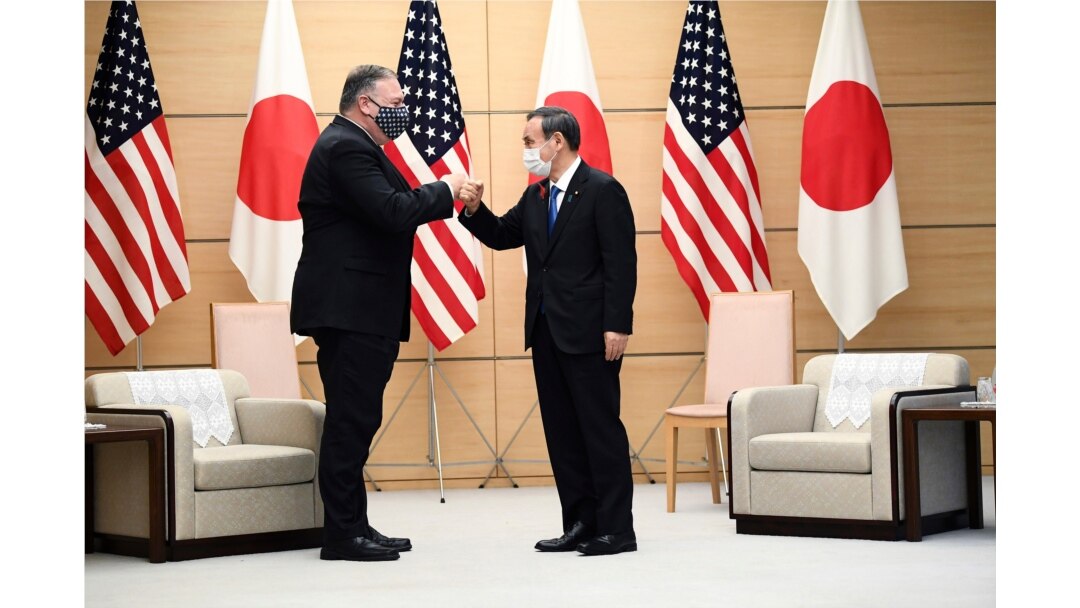 Japan's Prime Minister Yoshihide Suga, right, and U.S. Secretary of State Mike Pompeo greet at the prime minister's office in Tokyo, Oct. 6, 2020, ahead of the four Indo-Pacific nations' foreign ministers meeting.