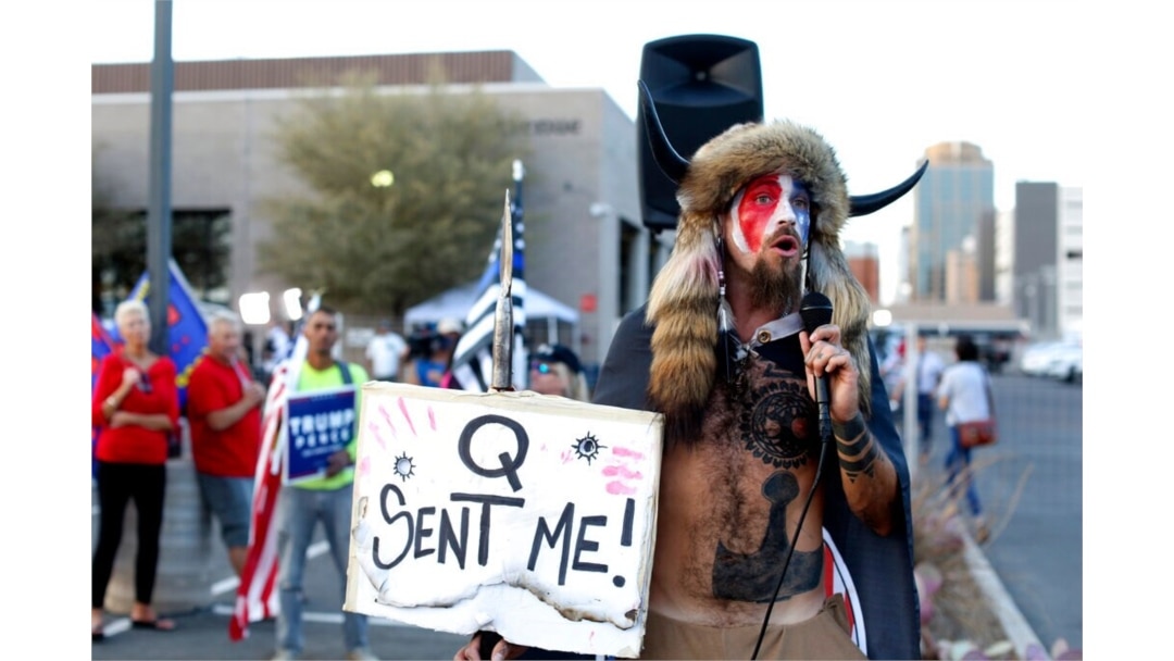 FILE - Jacob Anthony Chansley, who also goes by the name Jake Angeli, a QAnon follower, speaks to supporters of then-President Donald Trump outside of the Maricopa County Recorder's Office, in Phoenix, Nov. 5, 2020.