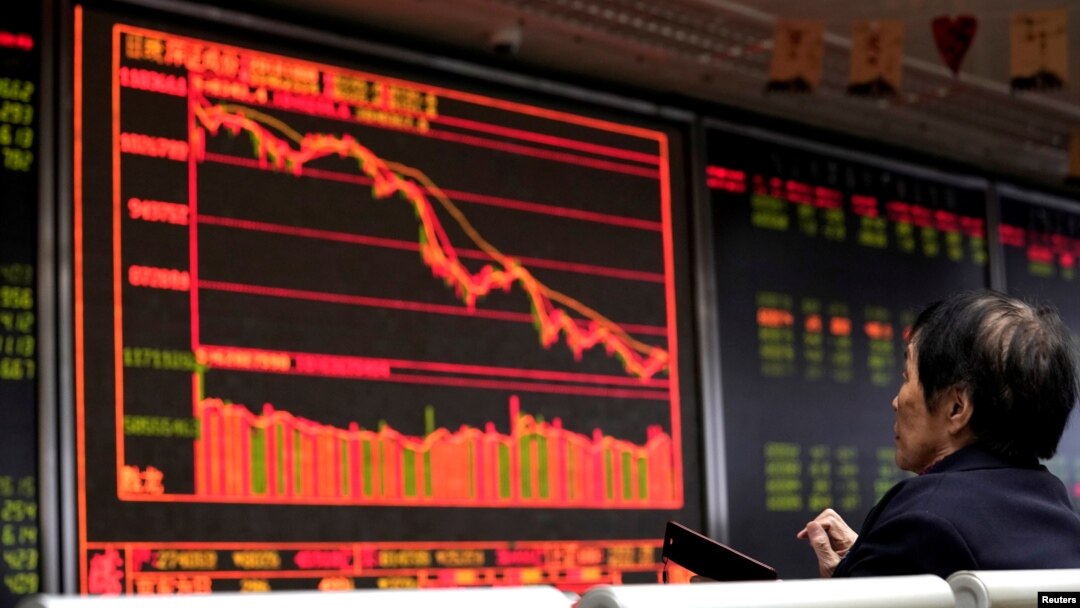 FILE - An investor watches a board showing stock information at a brokerage office in Beijing, China, Oct. 8, 2018.