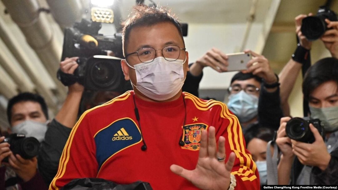 港媒《立場新聞》副採訪主任陳朗昇在離開辦公室時向香港媒體招手。 （2021年12月29日）