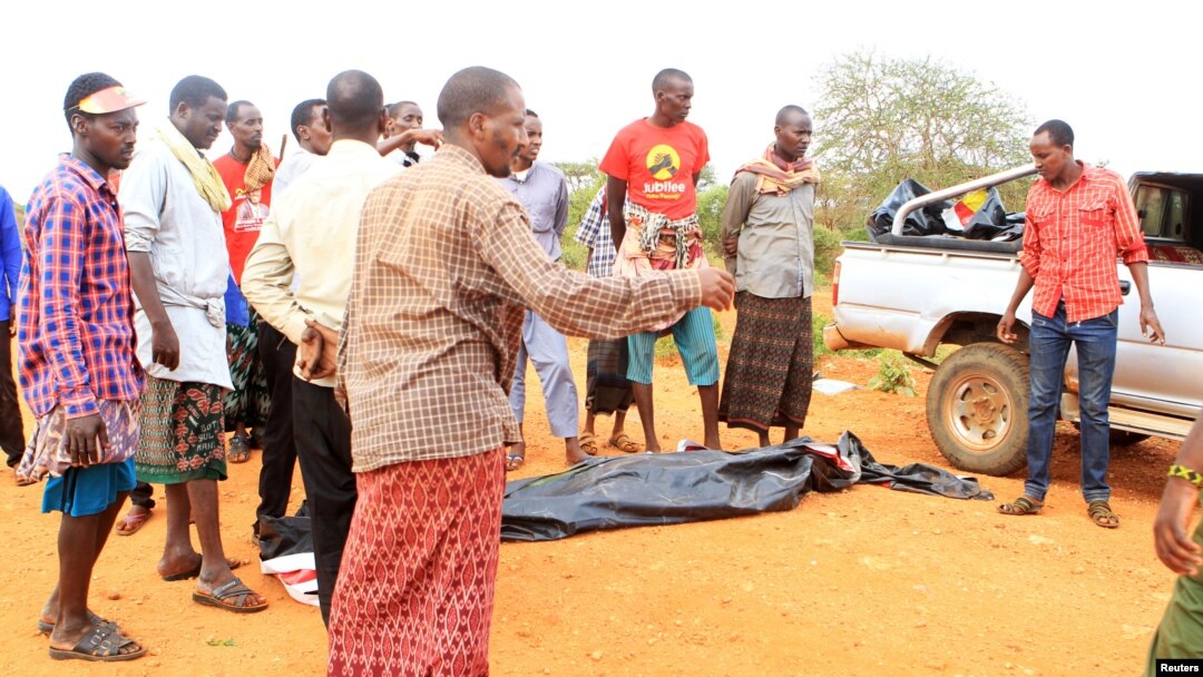 People stand near a body at the scene where a blast killed Kenyan police officers at the Garissa county, eastern Kenya, May 24, 2017. 