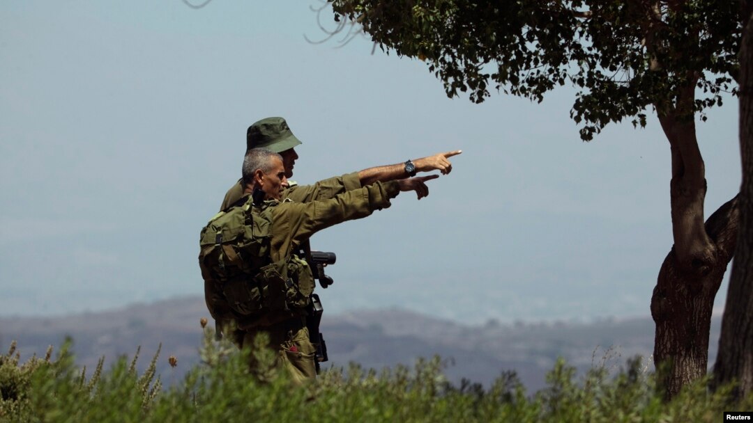 FILE - Israeli soldiers observe the Syrian side of the Quneitra border crossing between the Israeli-controlled Golan Heights and Syria, August 29, 2014. 