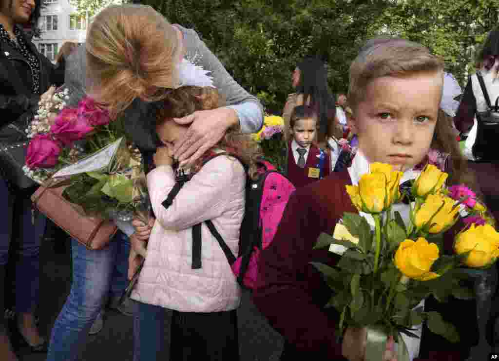 A girl in the first grade cries during a ceremony marking the start of classes at a school as part of the traditional opening of the school year known as "Day of Knowledge" amid the ongoing COVID-19 pandemic in St. Petersburg, Russia.