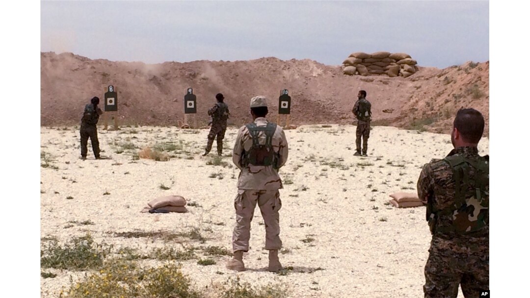 Syrian Arab trainees practice firing their small arms at an undisclosed training range in northern Syria on May 21, 2016.