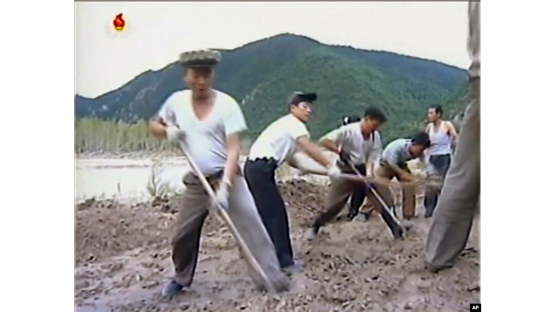 In this undated image from video distributed on Sept. 12, 2016, by North Korean broadcaster KRT, North Korean workers build levees along a river bank.