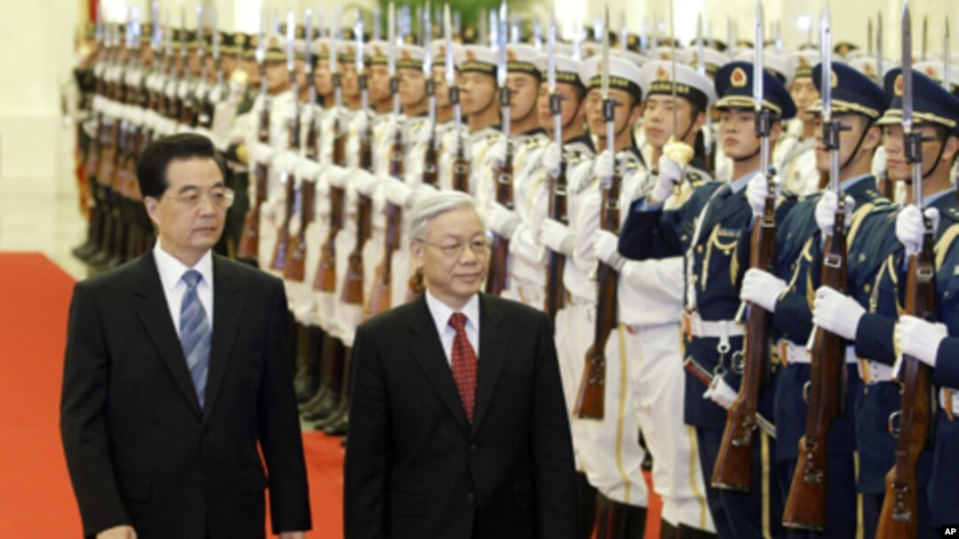 China's President Hu Jintao (L) and Vietnam's Communist Party General Secretary Nguyen Phu Trong walk past a guard of honor during a welcoming ceremony at the Great Hall of the People in Beijing October 11, 2011.
