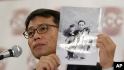 1969년 북한의 대한항공 납치 피해자 황원 씨의 아들인 황인철 씨가 지난해 5월 기자회견에서 어린 시절 아버지와 찍은 사진을 들어 보이고 있다.