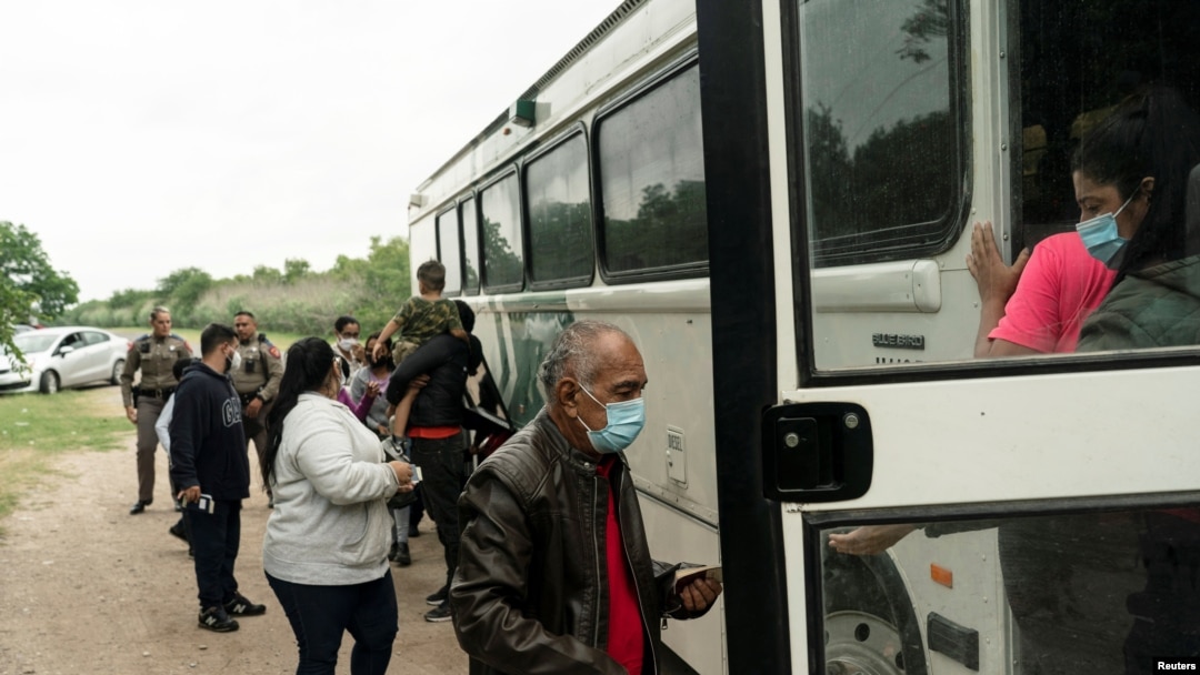 Asylum-seeking migrants from Venezuela board a U.S. Border Patrol's bus to be transported after crossing the Rio Grande River into the United States from Mexico in Del Rio, Texas, May 27, 2021. 