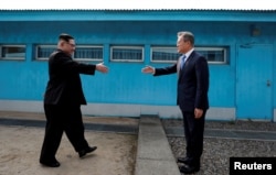 2018年4月27日，南韓總統文在寅和北韓領導人金正恩在南北韓之間的非軍事區內的板門店休戰區握手。