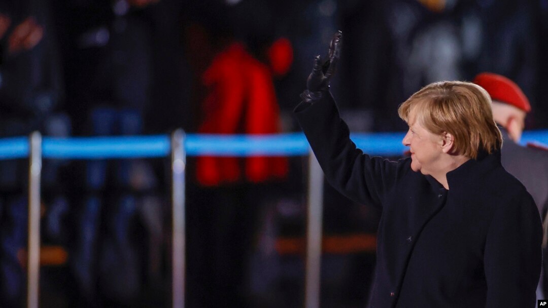 German Chancellor Angela Merkel waves goodbye at the Defense Ministry during the Grand Tattoo (Grosser Zapfenstreich), a ceremonial send-off for her in Berlin on Dec. 2, 2021.