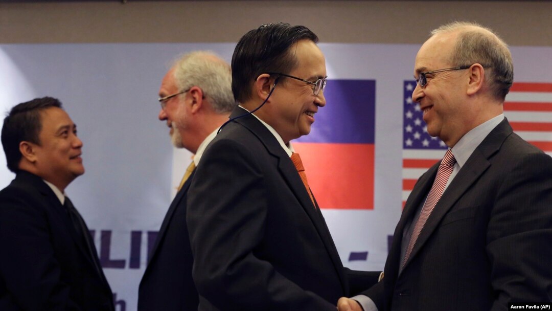U.S. Assistant Secretary of State Daniel Russel, right, shakes hands with Philippine Undersecretary of Foreign Affairs Evan P. Garcia,after their press conference on the fifth Philippines-United States Bilateral Strategic Dialogue in Manila, Philippines Wednesday, Jan. 21, 2015. (AP Photo/Aaron Favila)