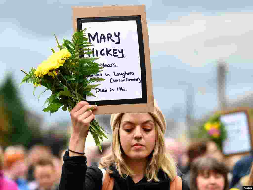 A woman attends a vigil at the site of the Tuam babies graveyard where the bodies of 796 babies where uncovered at a site of a former catholic home for unmarried mothers and their children in Tuam, Ireland, Aug. 26, 2018.