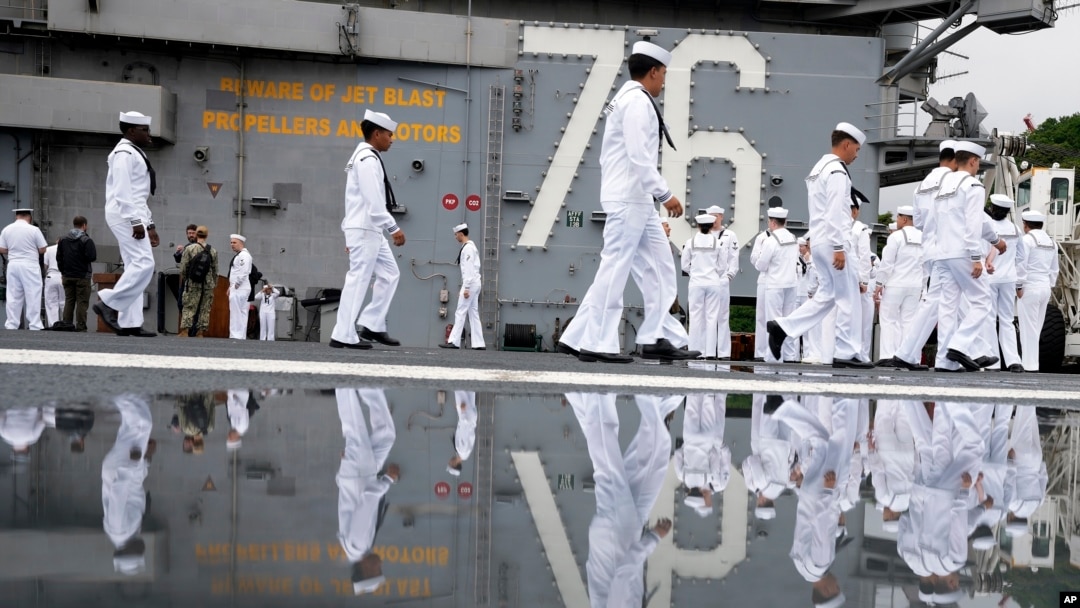 FILE - Crew of the U.S. navy aircraft carriers USS Ronald Reagan rig a ship for the voyage at the US navy's Yokosuka base, May 16, 2024, in Yokosuka, south of Tokyo. This is the ship's final departure from Yokosuka before transiting back to the US.
