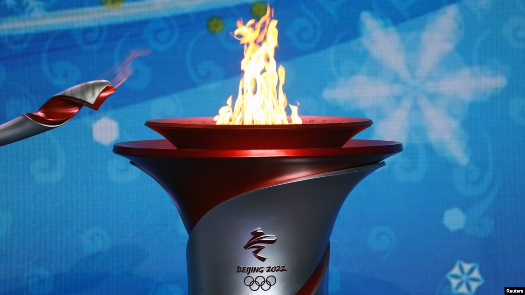 20일 베이징에 도착한 2022 동계올림픽 성화가 환영식 현장에 설치된 성화대로 옮겨지고 있다.