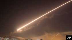 FILE - Damascus skies erupt with surface to air missile fire as the U.S. launches an attack on Syria targeting different parts of the Syrian capital Damascus, Syria, April 14, 2018.