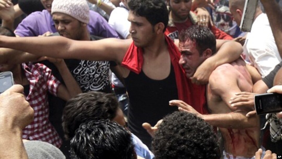 A protester protects a detained "thug" from other protesters who want to beat him during clashes between Islamist protesters and armed "thugs" in Cairo May 2, 2012.