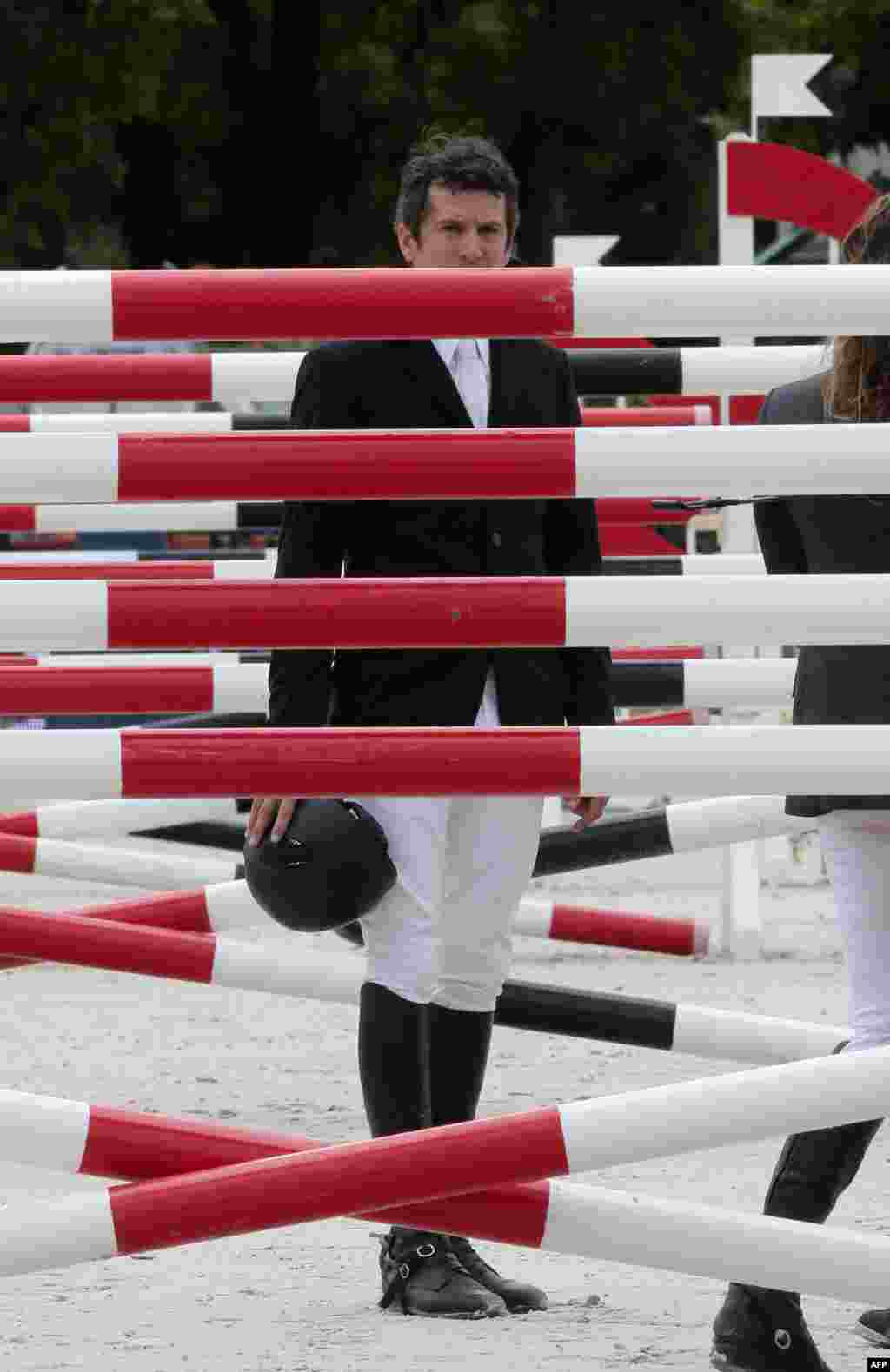 French actor and director Guillaume Canet looks on before competing in the six bar contest of the "Paris Eiffel Jumping" event at the Champs de Mars in Paris, near the Eiffel tower.