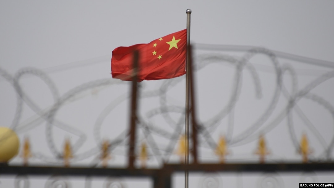 新疆喀什南部地區一處圍著鐵絲網的小區裡飄揚著中國國旗。（2019年6月4日）