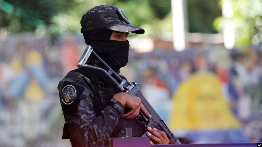 Una agente enmascarada de la Policía Nacional Bolivariana de Venezuela hace guardia en Petare, Caracas, el 22 de enero de 2025. 