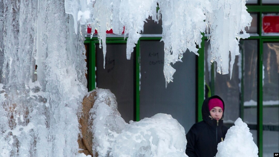 A woman passes an ice-covered fountain in New York's Bryant Park, Jan. 5, 2018. Frigid temperatures, some that could feel as cold as minus 30 degrees, moved across the East Coast on Friday as the region attempted to clean up from a massive winter storm. 