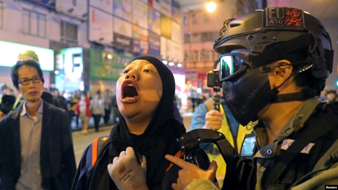 A protester is detained by a riot police officer during an anti-government rally outside Prince Edward MTR station in Hong Kong, China, Nov. 30, 2019.