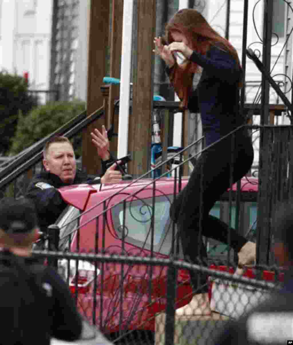 A barefooted woman runs for cover as police surround a home while searching for a suspect in the Boston Marathon bombings in Watertown, April 19, 2013.
