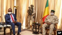 Kenya's Ambassador to the U.N. Martin Kimani, from Kenya, left, leads a United Nations Security Council mission meeting with Transition President Col. Assimi Goita, right, in Bamako, Mali, Oct. 24, 2021. 
