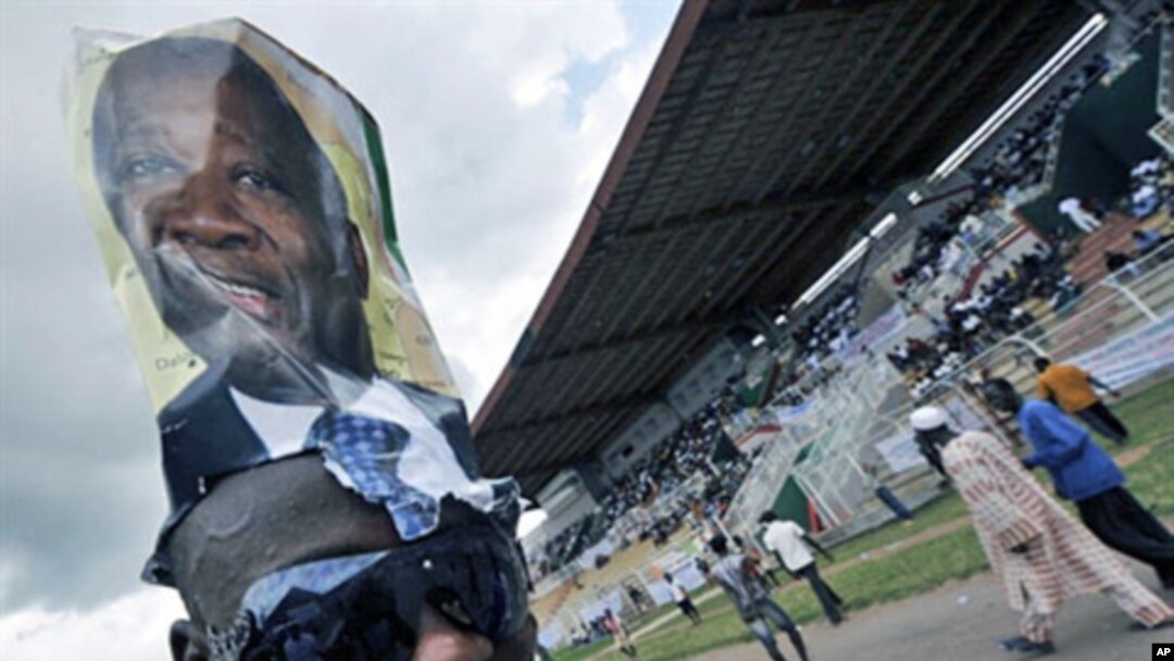 A supporter wears a poster on his head of Ivory Coast Laurent Gbagbo during a rally at a stadium in Bouake ahead of the 31 Oct 2010 elections (File)