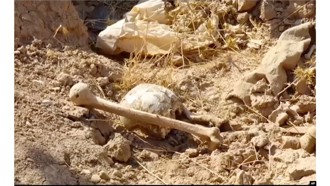 Bones lie on the ground in an area recently retaken from the Islamic State group, at an abandoned base near the northern town of Hawija, Iraq, Nov. 11, 2017.