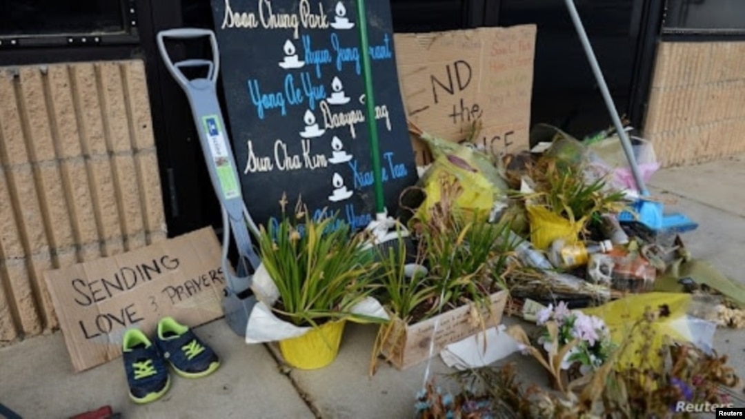 Flores secas, letreros y varias escobas, escurridores y palas bloquean la entrada del Aromatherapy Spa, en Atlanta, cuatro semanas después de los mortales tiroteos en Atlanta y Acworth, Georgia, el 13 de abril de 2021.