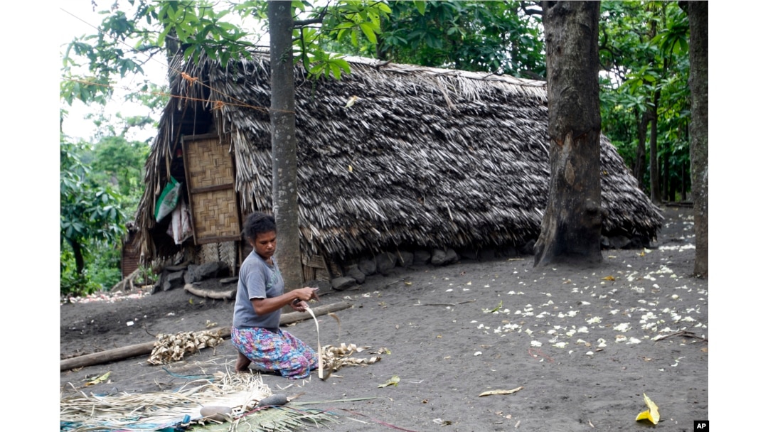 FILE - A woman weaves a mat in a village on Tanna Island in Vanuatu, June 2, 2015. Tanna Island was particularly hard hit by Cyclone Pam, which struck in March of that year. Many people in Vanuatu believed the cyclone was a manifestation of climate change.