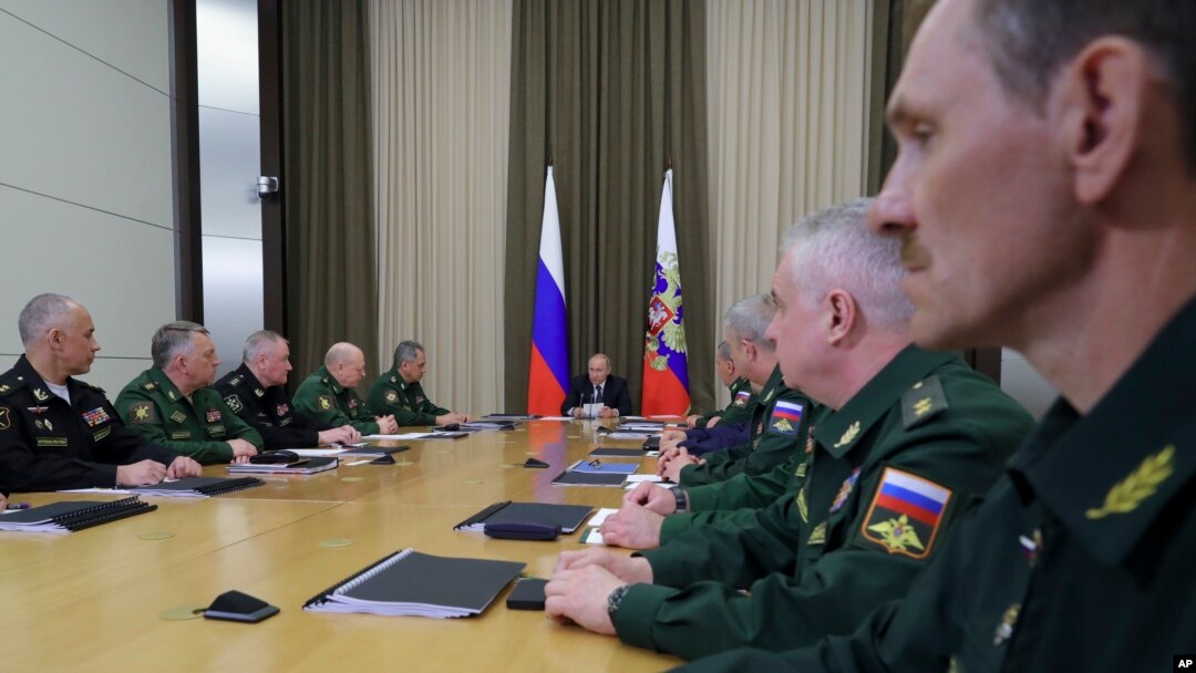 Russian President Vladimir Putin, background center, leads a meeting with the top military brass in the Bocharov Ruchei residence in the Black Sea resort of Sochi, Russia, May 15, 2018. Putin says the new weapons presented this year will ensure Russia's security for decades to come.