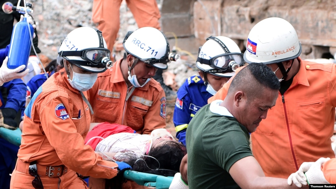 A rescue team carries a wounded worker at a collapsed building in Sihanoukville, Cambodia, June 22, 2019.