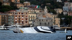 Boats are washed ashore, a day after a storm, in Rapallo, northern Italy, Oct. 30, 2018. 