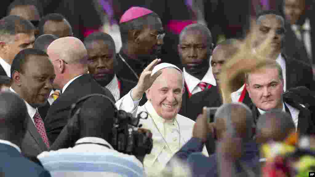 Paparoma Francis a tsakiya yana dagawa masu rawar gargajiya hannu tare da shugaban kasar Uganda 
