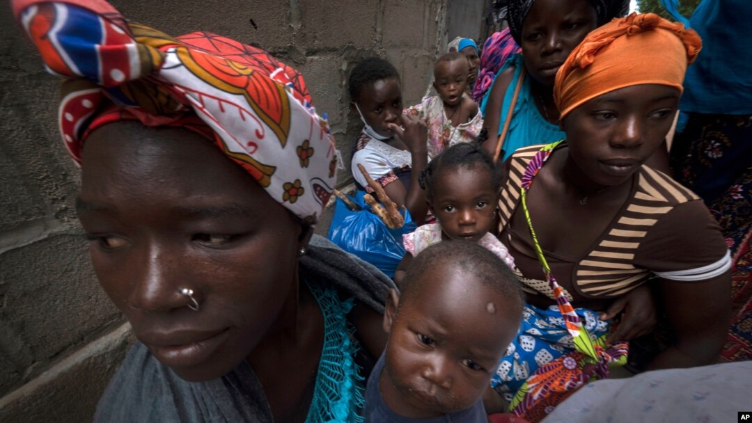 Displaced women with their children wait for assistance at a building used by refugees as shelter in Pemba, Mozambique, after they fled attacks in Palma in northern Mozambique, April 19, 2021.