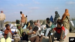 FILE - Somali refugees wait for a plane to take them home from Dabaab refugee camp in northern Kenya.