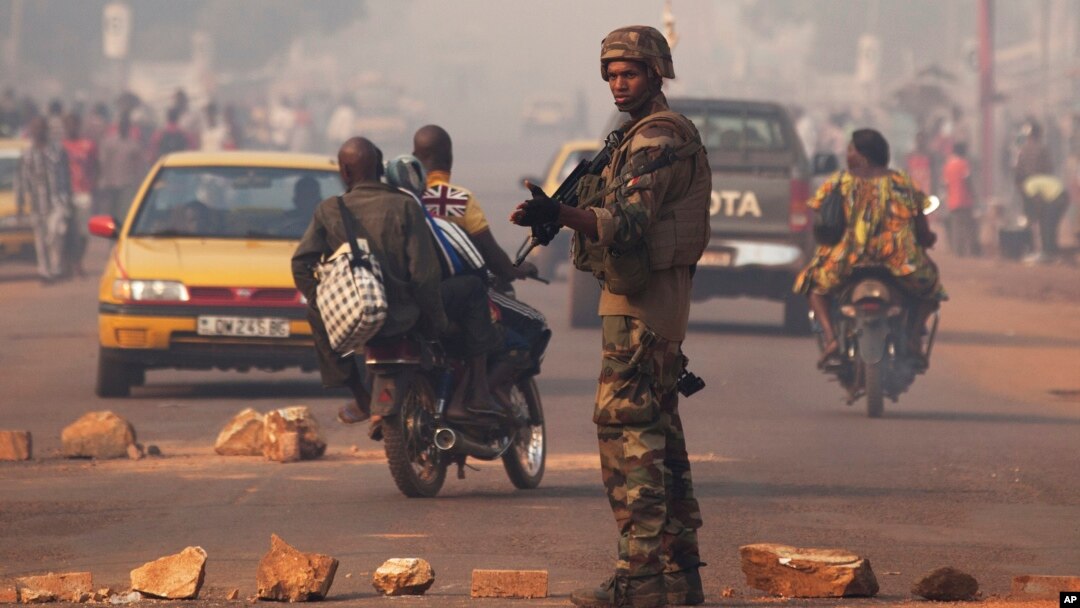 A French soldier waves through traffic as he mans a roadblock in the Miskine neighborhood of Bangui, Central African Republic, Jan. 6, 2014. 