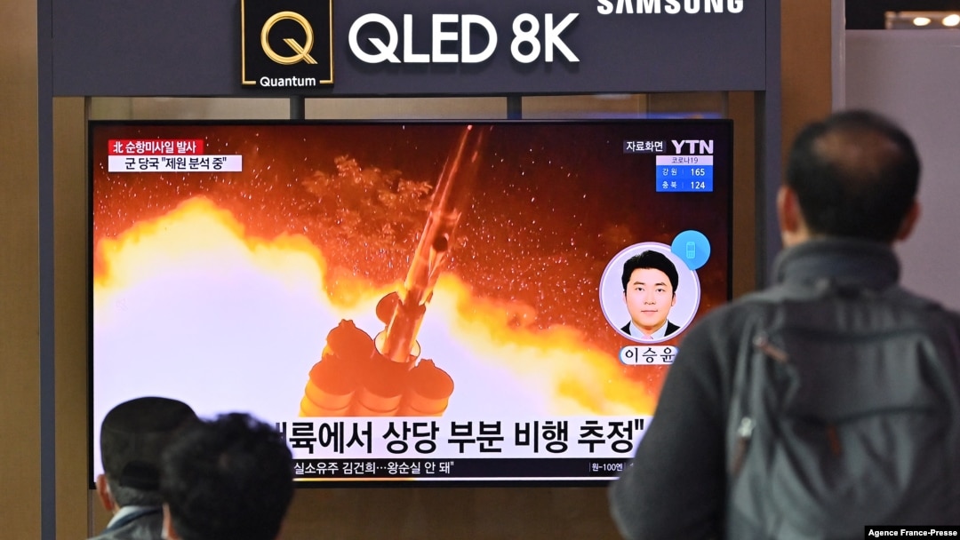 People watch a television screen showing a news broadcast with file footage of a North Korean missile test, at a railway station in Seoul on Jan. 25, 2022.
