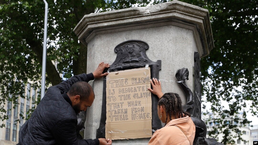 A banner is taped over the inscription on the pedestal of the toppled statue of Edward Colston in Bristol, England, June 8, 2020.