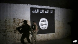 Un soldado iraqui inspecciona un túnel de trenes recién descubierto, adornado con una bandera del grupo Estado Islámico en el occidente de Mosul en Irak. Marzo 1, 2017.