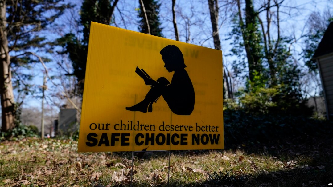 A sign that reads "our children deserve better safe choice now" is seen on Friday, Jan. 15, 2021, in Decatur, Ga., just down the road from the U.S. Centers for Disease Control and Prevention. (AP Photo/Brynn Anderson)